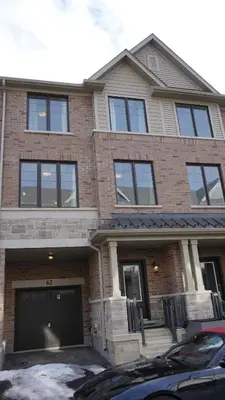 a brick house with a car parked in front of it at Newly Built 3 plus 1 bedroom Ravine lot Townhouse, Brampton, Ontario in Brampton