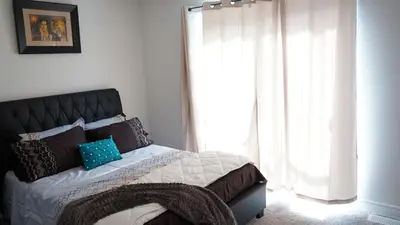 a bedroom with a bed with a large window at Newly Built 3 plus 1 bedroom Ravine lot Townhouse, Brampton, Ontario in Brampton