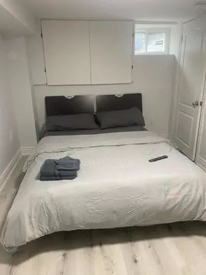 a large bed in a bedroom with a white cabinet at 2 bedroom 2 bath separate basement unit in Cambridge