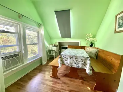 a green room with a table and a window at Cozy 1 bedroom 4 mins to falls in Niagara Falls