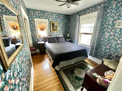 a bedroom with a bed in a room with blue wallpaper at Entire guest suite in the Falls in Niagara Falls