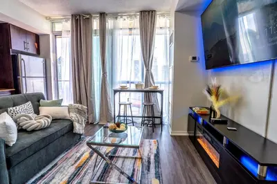 a living room with a couch and a tv at Exquisite Living Toronto in Toronto