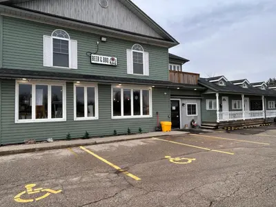 a parking lot in front of a green building at Smokehouse Suites and Stay in Guelph