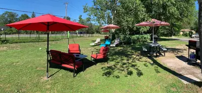 a group of chairs and umbrellas in a yard at Wasaga Motel Inn in Wasaga Beach