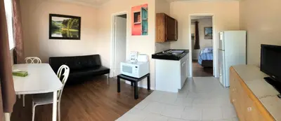 a kitchen and living room with a couch and a table at Wasaga Motel Inn in Wasaga Beach