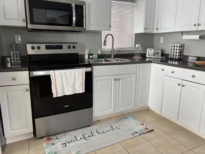 a kitchen with a black stove and a microwave at Waterfront Cottage Near Toronto Private Dock, Water Crafts, BBQ Wi-Fi - Sleeps 4 in Manvers