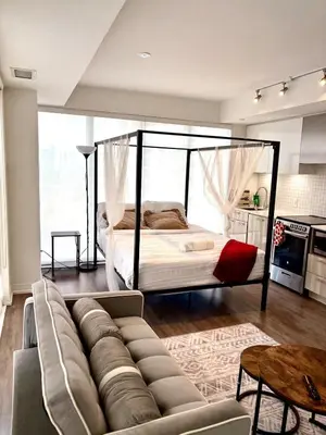 a living room with a couch and a bed at Sweetheart studio with city views in Toronto