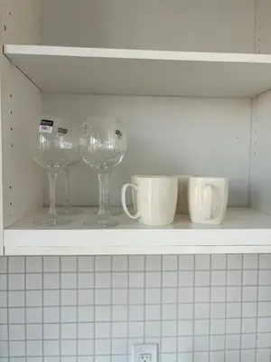 three wine glasses and cups sitting on a shelf at Sweetheart studio with city views in Toronto