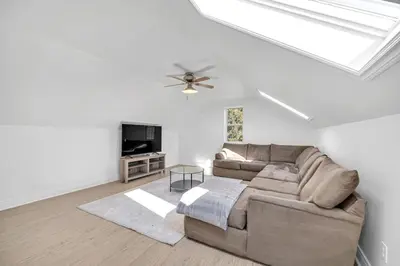 a living room with a couch and a television at Vintage 8BR Farmhouse With Hot Tub Spacious Yard in Port Colborne