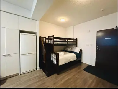 a small bedroom with a bunk bed and a refrigerator at KingBed & Bunkbed & Terrace in Toronto