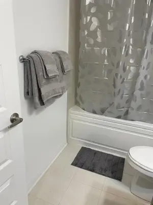 a bathroom with a shower curtain and a toilet at Executive Luxury Apartment in Oakville