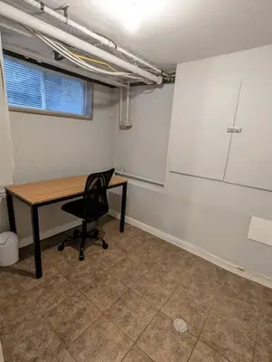 an empty office with a desk and a chair at Charming Basement Studio Bathroom Full Kitchen in Toronto