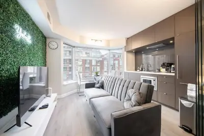 a living room with a couch and a kitchen at Discounted Elegant Yorkville Suite in Toronto