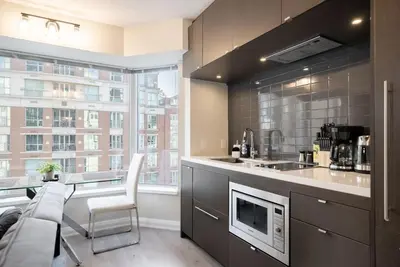 a kitchen with a counter with a sink and a microwave at Discounted Elegant Yorkville Suite in Toronto