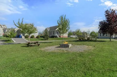 a park with a fire pit in the grass at Le Papillon - 77 Butternut in Cherry Valley