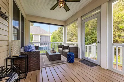 a screened in porch with a ceiling fan and a couch at Le Papillon - 77 Butternut in Cherry Valley