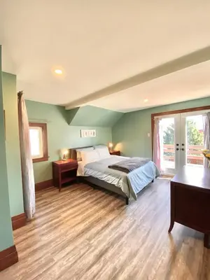 a bedroom with a bed and a wooden floor at Cozy Suite-Walk to the Falls in Niagara Falls