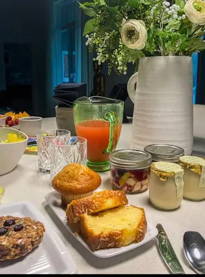 a table topped with plates of pastries and orange juice at The Studio Southampton in Southampton