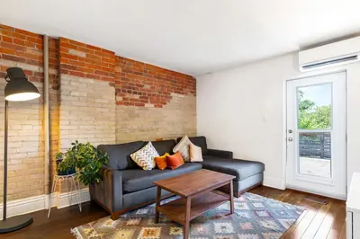 a living room with a couch and a brick wall at Stylish & Spacious 3BR in Downtown Toronto in Toronto