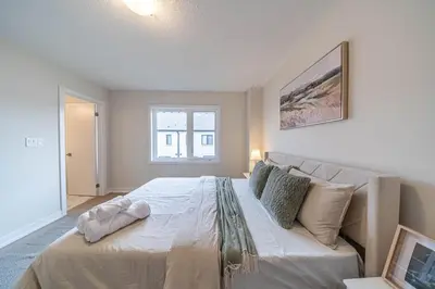 a bedroom with a large bed and a window at Entire home in Oakville, Canada in Oakville
