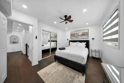 a white bedroom with a bed and a ceiling fan at Hidden 3BR Gem with Workspace, Fast wifi and Parking in Toronto