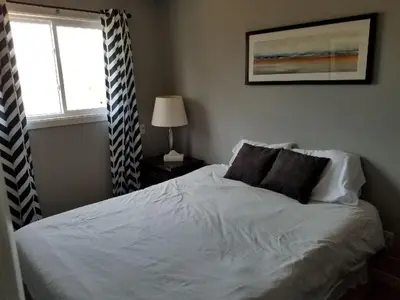 a bedroom with a white bed with a window at The Rosehall PEC Waterfront Stay in Wellington