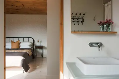 a bedroom with a bed with a sink and a mirror at Willow Creek - Modern Sunlit Bungalow in Hillier