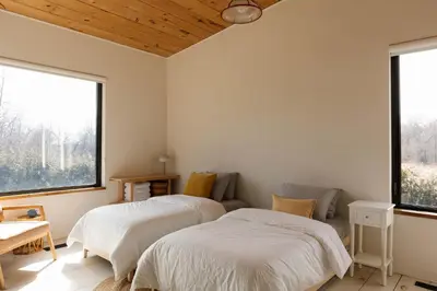two beds in a room with two windows at Willow Creek - Modern Sunlit Bungalow in Hillier