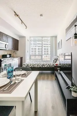 a kitchen and a living room with a table at Luxury CN Tower Suites - Save on Monthly Stays in Toronto