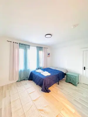 a bedroom with a bed with a blue comforter at Bright 2bedroom apartment in Hamilton