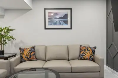 a living room with a couch and a picture on the wall at Baker Hill Executive Suite 2 Br Basement Apartment with Full Kitchen and Bath in Stouffville