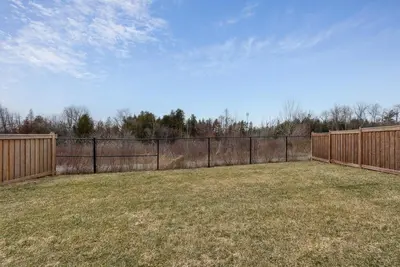 a fenced in yard with a fence and trees at Baker Hill Executive Suite 2 Br Basement Apartment with Full Kitchen and Bath in Stouffville