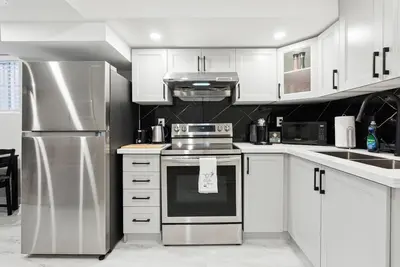 a kitchen with white cabinets and stainless steel appliances at Baker Hill Executive Suite 2 Br Basement Apartment with Full Kitchen and Bath in Stouffville