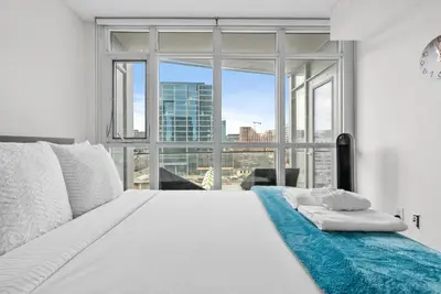 a bedroom with a white bed with a large window at Apartment in Downtown Toronto in Toronto