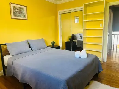 a bedroom with a large bed with yellow walls at Cozy Stay, Self Check-In with Parking available upon request in Toronto