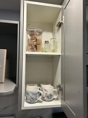 a cupboard with two cups and other items in it at Beautiful and cozy unit in Mississauga