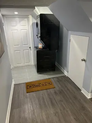 a hallway with a white door and a black refrigerator at Beautiful and cozy unit in Mississauga