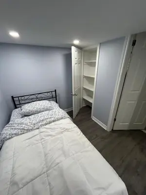 a bedroom with a large white bed and a closet at Beautiful and cozy unit in Mississauga