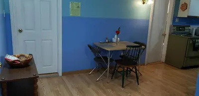 a kitchen with a table and chairs and a blue wall at 2 bdrm apartment 3 min walk to McMaster University in Hamilton