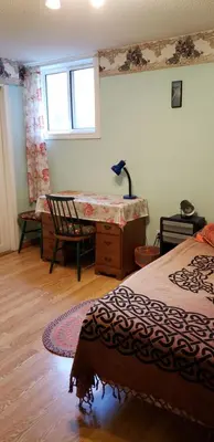 a bedroom with a bed and a desk and a window at 2 bdrm apartment 3 min walk to McMaster University in Hamilton