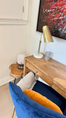 a blue chair sitting next to a desk with a lamp at Bright Luxurious 2 Bedroom Apartment in Toronto
