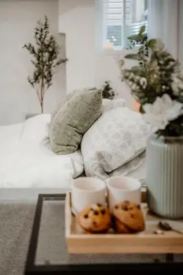 a tray with cookies on a table in front of a bed at The Barrie Nook in Barrie
