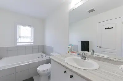 a white bathroom with a sink and a toilet at Modern Home 10 mins from Niagara Falls & Main Attraction with Free 2 Parkings in Thorold