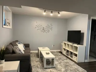 a living room with a couch and a flat screen tv at Just like home 1 bedroom appt in Guelph