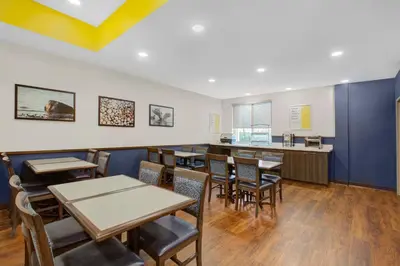 a dining room with tables and chairs and a counter at Days Inn & Suites by Wyndham Lindsay in Lindsay