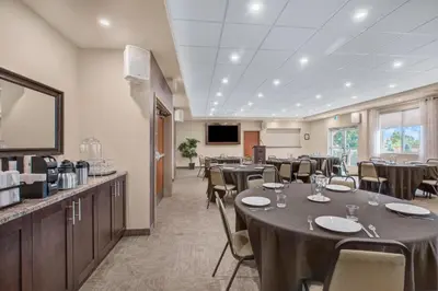 a conference room with tables and chairs and a television at Days Inn & Suites by Wyndham Lindsay in Lindsay