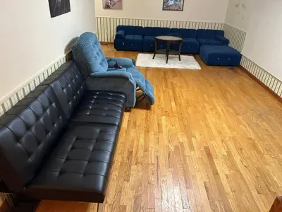 a living room with a black leather couch and a table at Charming Farmhouse in Grafton