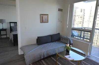 a living room with a couch and a glass table at Condo at Yonge-Sheppard Station, North York in Toronto