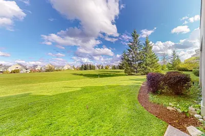 a yard with a green field with a tree at Wintergreen 122 in Blue Mountains