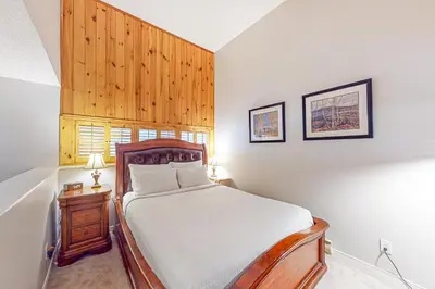 a bedroom with a bed and a wooden headboard at Wintergreen 122 in Blue Mountains